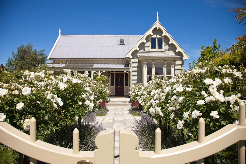 a house with white roses in front of it at Lilac Rose Boutique Bed and Breakfast in Christchurch