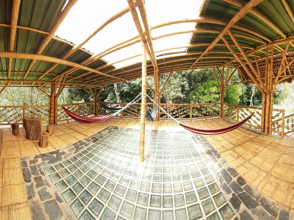 a pavilion with hammocks in the middle of a room at Colibamboo Ecolodge Biocasa artesanal rodeada de naturaleza con jaccuzi y mucho más in Pacho