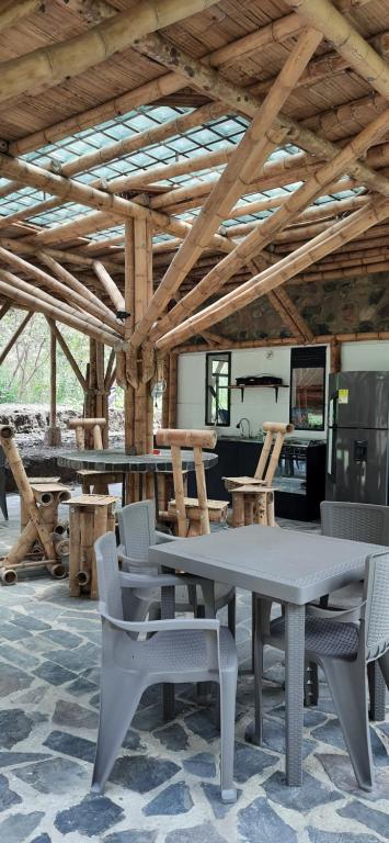 a table and chairs in a room with wooden ceilings at Colibamboo Ecolodge Biocasa artesanal rodeada de naturaleza con jaccuzi y mucho más in Pacho