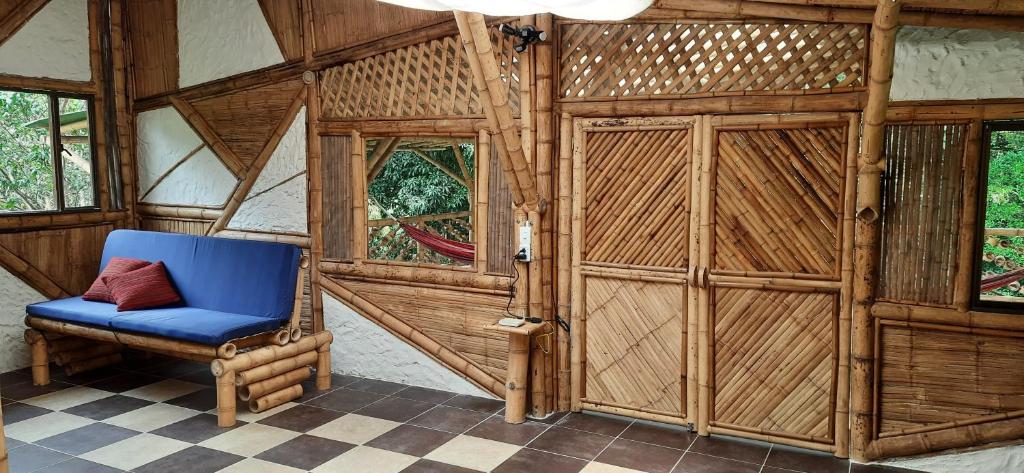 a room with a blue chair in a room with wooden walls at Colibamboo Ecolodge Biocasa artesanal rodeada de naturaleza con jaccuzi y mucho más in Pacho