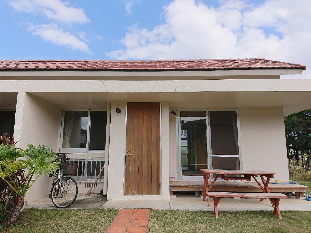 una casa con una mesa de picnic delante de ella en Kaeruya, en Nakijin