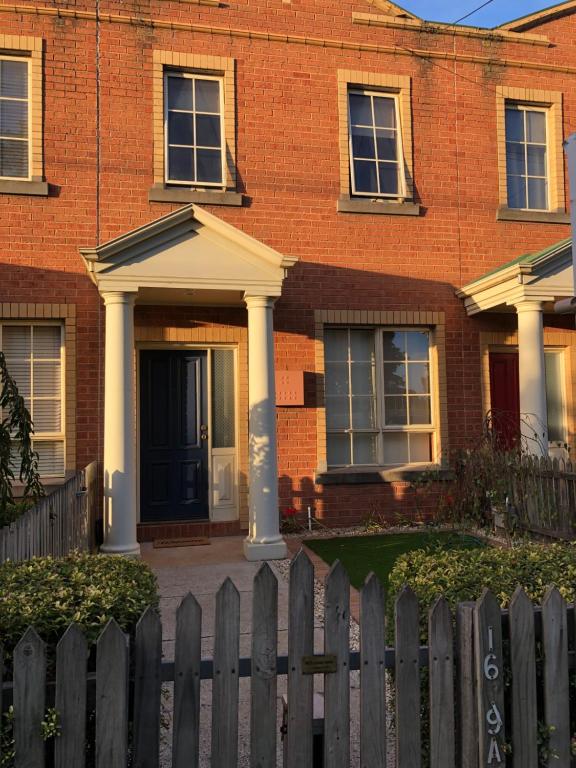 a brick house with a wooden fence in front of it at Serenity on Sturt in Ballarat