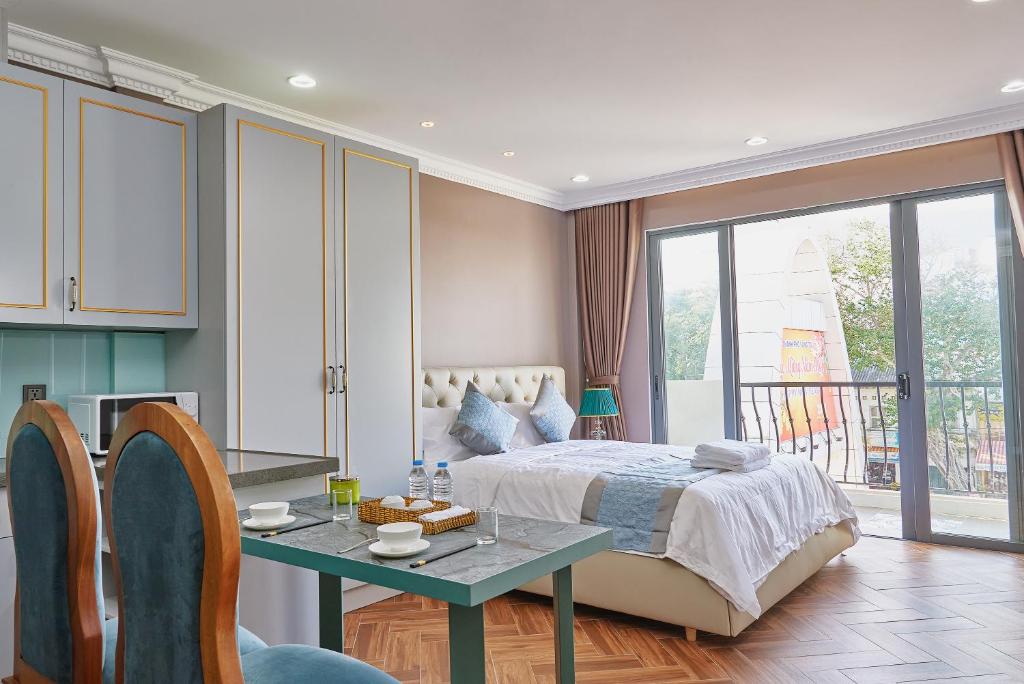een slaapkamer met een bed en een tafel en een eetkamer bij The Alcove Apartment Vung Tau in Vung Tau