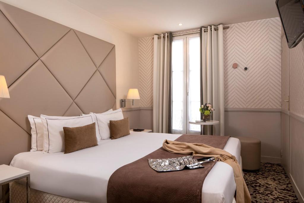 パリにあるロンシャン エリゼの白い大型ベッド1台と窓が備わるホテルルームです。