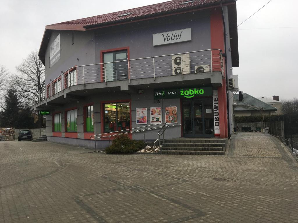 a building with a dog sitting outside of it at VOTIVI in Sanok