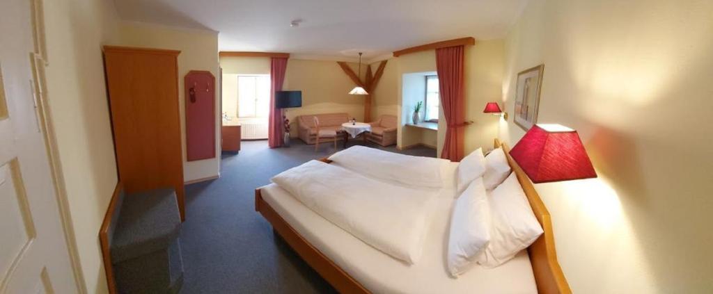 ティーフェンバッハにあるGasthof Russenbräuの白いベッドと赤いランプが備わるホテルルームです。