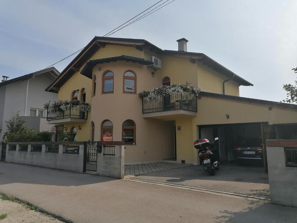 a house with a scooter parked in front of it at Garden Blue Sarajevo - free Parking in Sarajevo