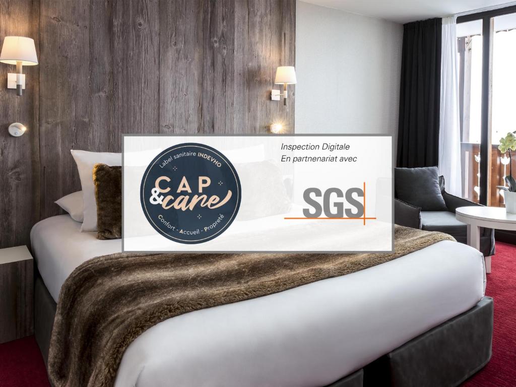 a hotel room with a bed with a sss sign on it at Le Pic Blanc in L'Alpe-d'Huez
