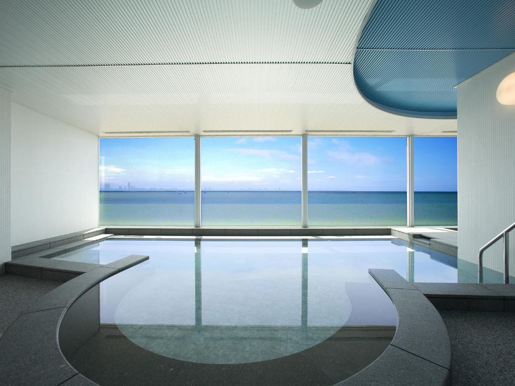 a swimming pool with a view of the ocean at Mitsui Garden Hotel Prana Tokyo Bay in Urayasu