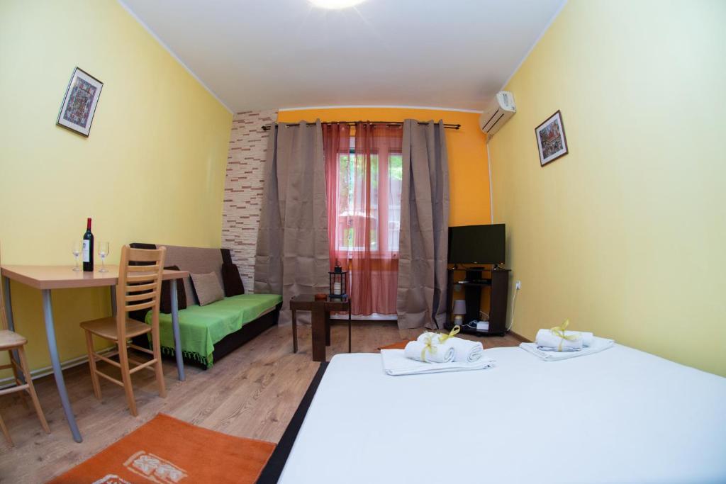a room with two beds and a table and a chair at Apartment Kalemegdan in Belgrade