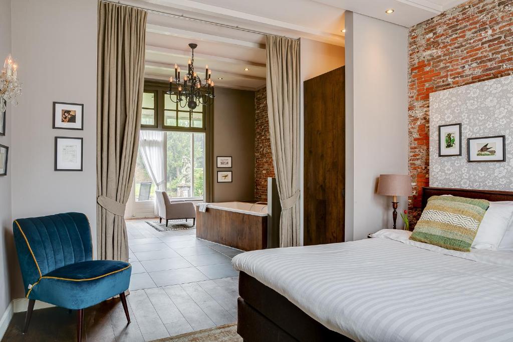 a bedroom with a bed and a desk and a chair at Boutique Hotel 't Vosje in Haarlem
