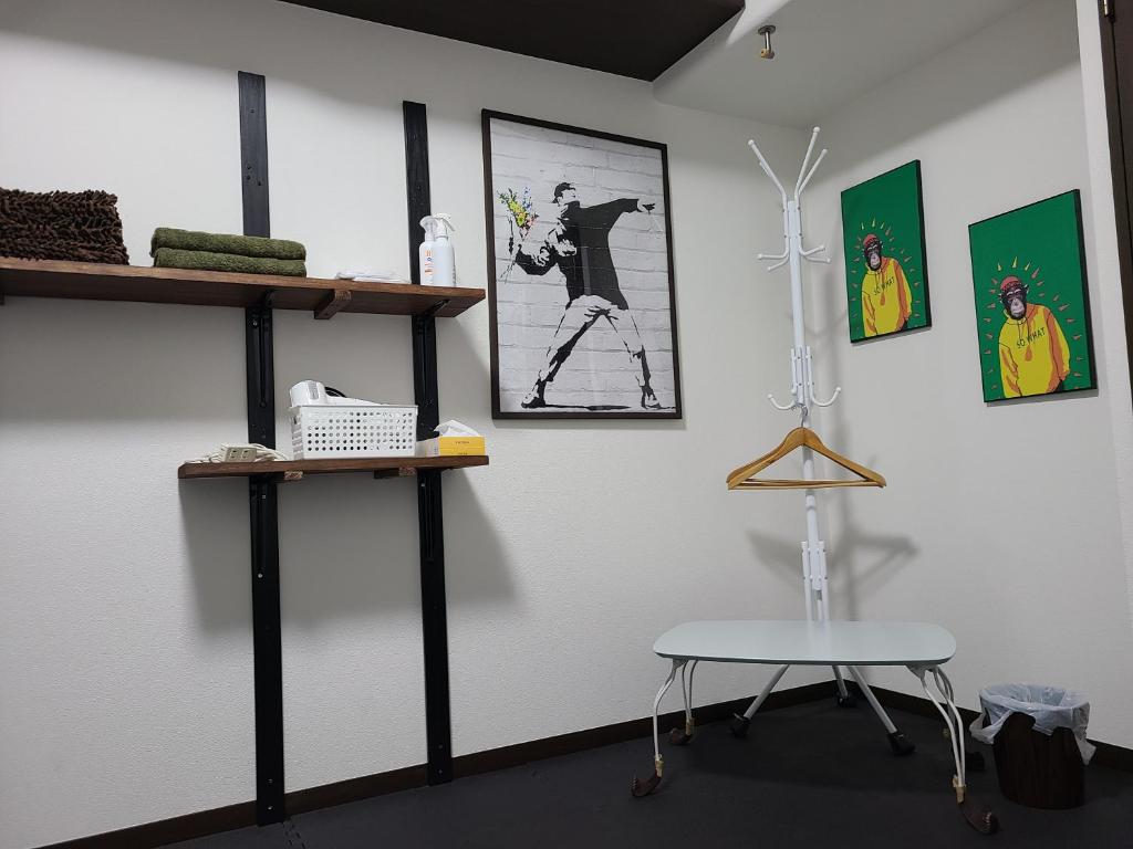 a room with shelves and a table and a chair at Nomad Apartment Stay in Kumamoto