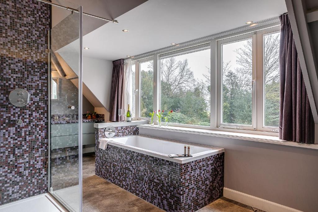 a bathroom with a large bath tub and a window at Boutique Hotel 't Vosje in Haarlem
