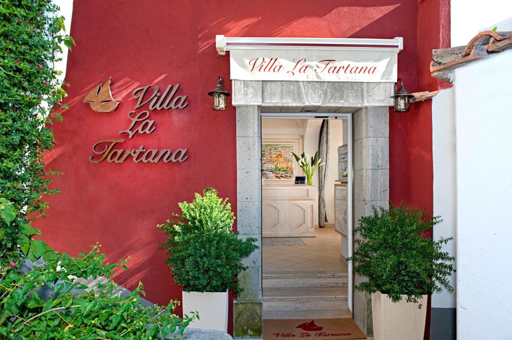 a red building with a sign that reads villa for karma at Villa La Tartana in Positano