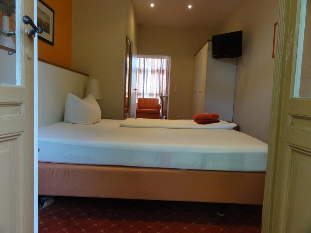a bedroom with a bed and a chair in a room at Pension Zeitlos in Potsdam