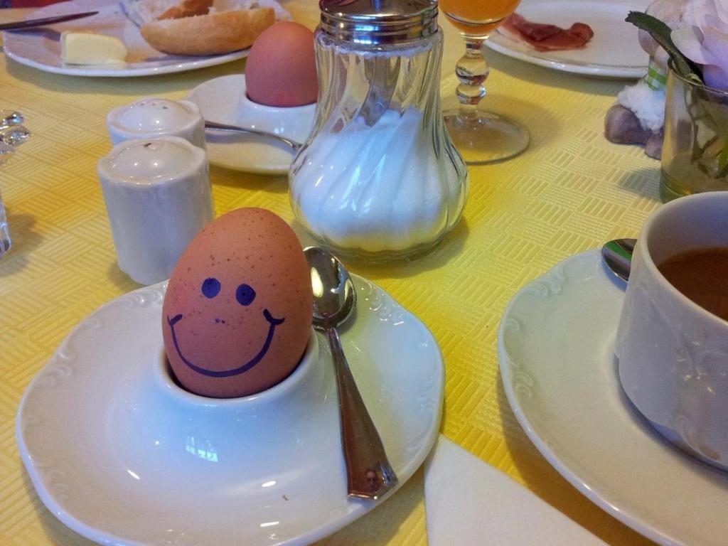 a egg with a smiley face drawn on it in a spoon at Parkhotel Ruhpolding in Ruhpolding