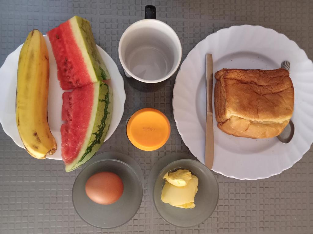 a table with a plate of food with a sandwich and eggs at Viriko Boarding House in Mombasa