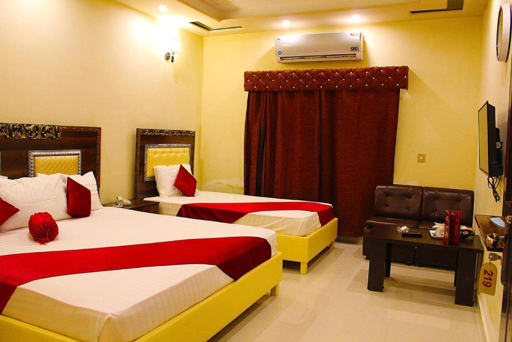 um quarto de hotel com duas camas e uma janela em Hotel Day In Lahore em Lahore