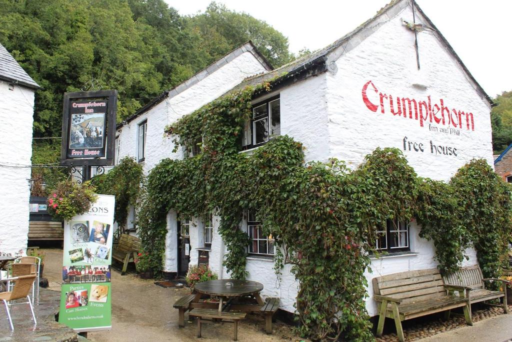 a white building with a bunch of ivy on it at The Crumplehorn Inn & Mill in Polperro