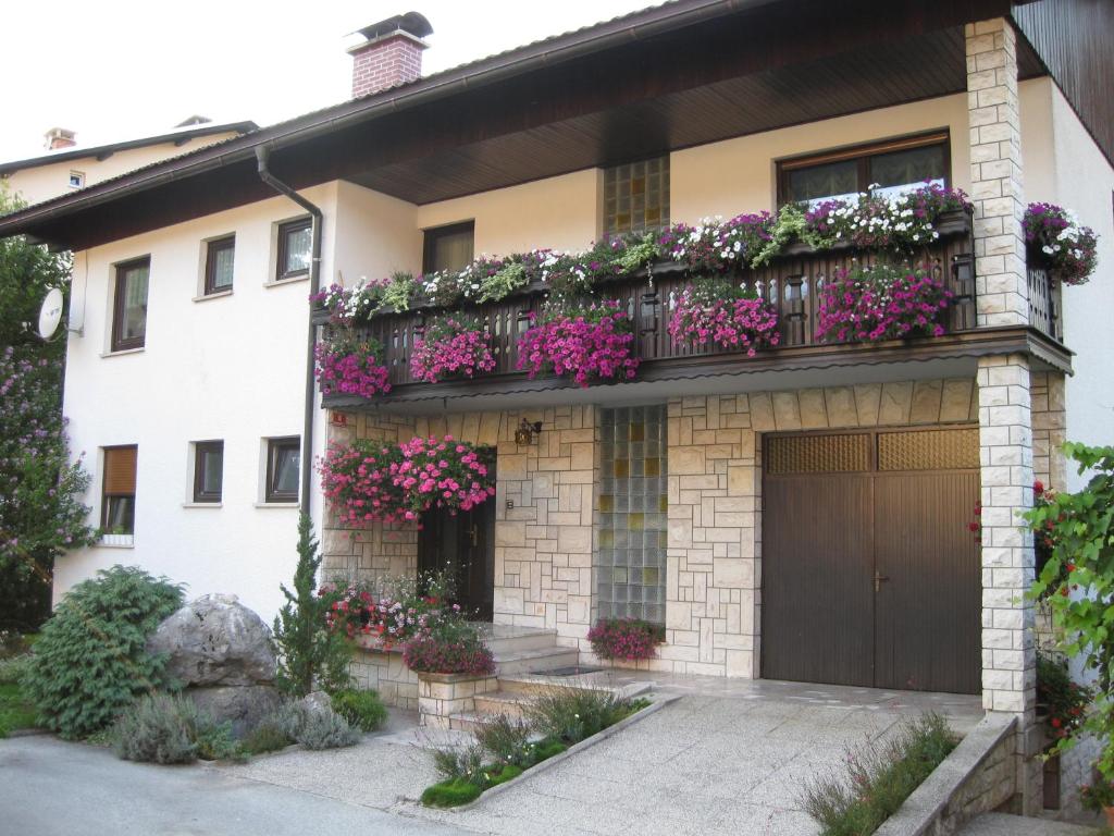 een huis met een balkon met bloemen erop bij Apartment Žvab in Bohinj