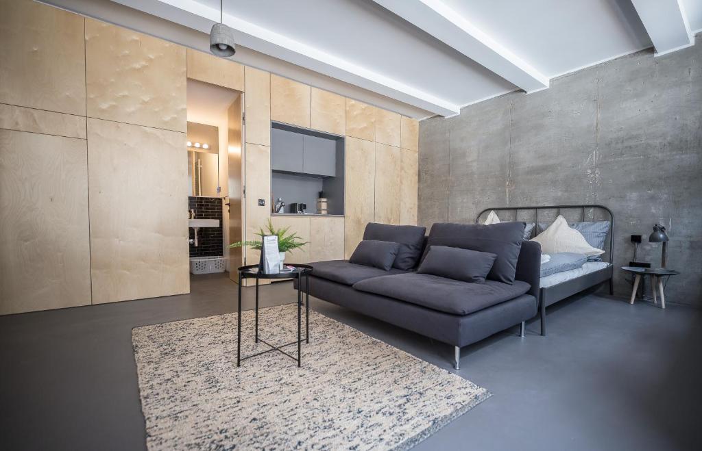 ein Wohnzimmer mit einem Sofa und einem Teppich in der Unterkunft Nena Apartments Metropolpark Berlin - Mitte -Adult Only in Berlin