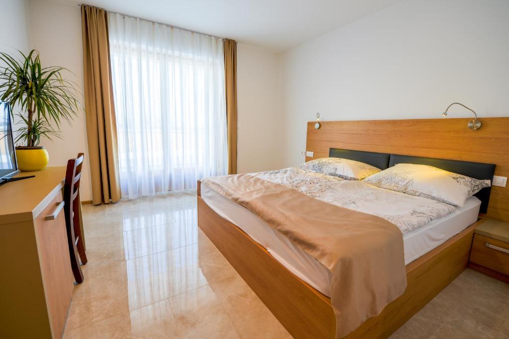 1 dormitorio con 1 cama grande y cabecero de madera en HOTEL BARON, en Smlednik