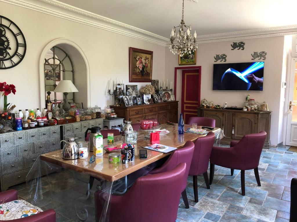 una sala da pranzo con tavolo e sedie viola di Aggarthi Bed and Breakfast a Bayeux