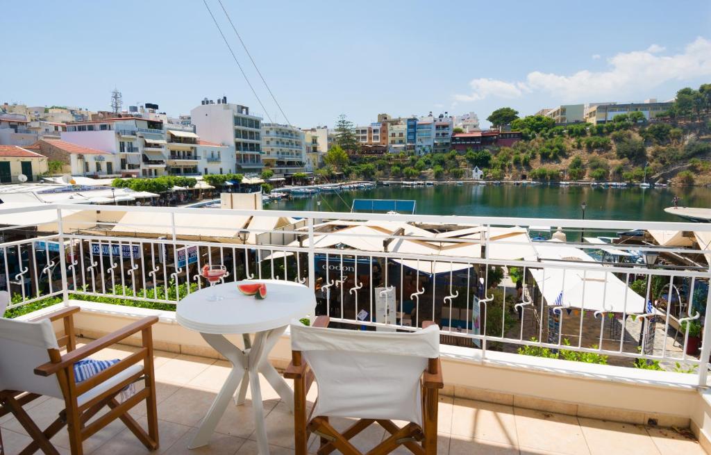 - Balcón con mesa, sillas y barco en Straight to the Lake View Apartments, en Agios Nikolaos