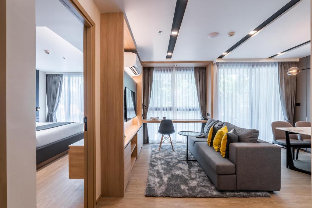 a room with a couch and a bed and a table at Destiny63 Ekamai Apartment in Bangkok
