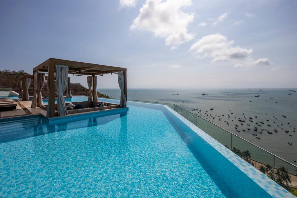 a swimming pool with a view of the ocean at Fusion Suites Vung Tau in Vung Tau