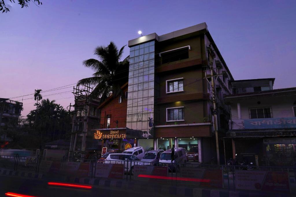 un edificio con auto parcheggiate di fronte di Hotel Heritage a Kuch Bihār