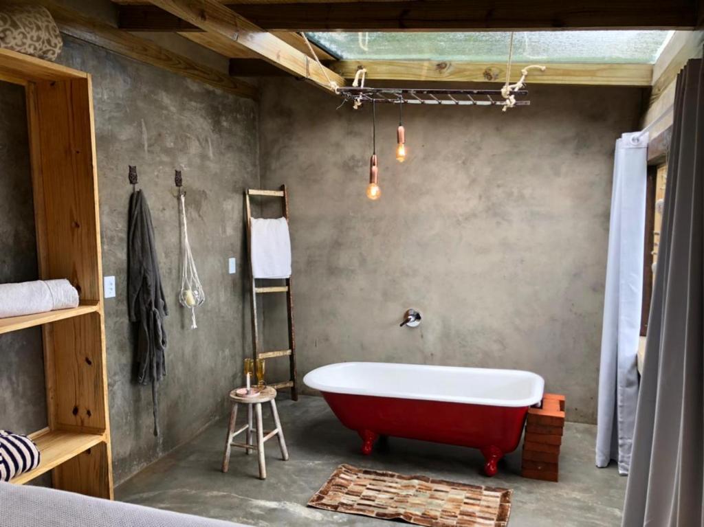Habitación con baño con bañera roja. en Cabana Monte - Pousada Colina dos Ventos, en Urubici