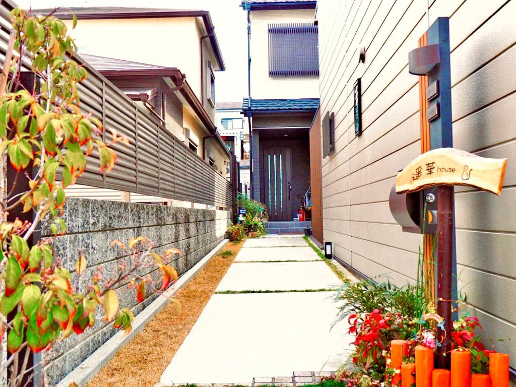 a walkway in the side of a building with flowers at 遥華-Haruka House in Kyoto
