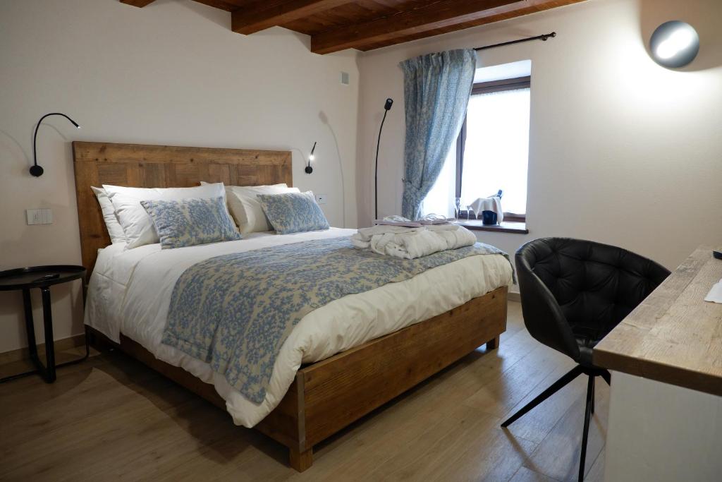 a bedroom with a bed and a desk and a window at Maison Bertin in Etroubles