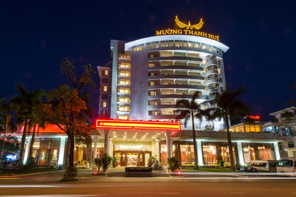 a building with a sign on top of it at night at Muong Thanh Holiday Hue Hotel in Hue