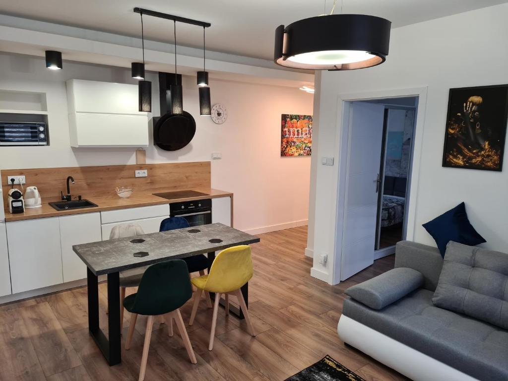 a kitchen and living room with a table and chairs at Paderewskiego Old Town Apartaments in Kraków