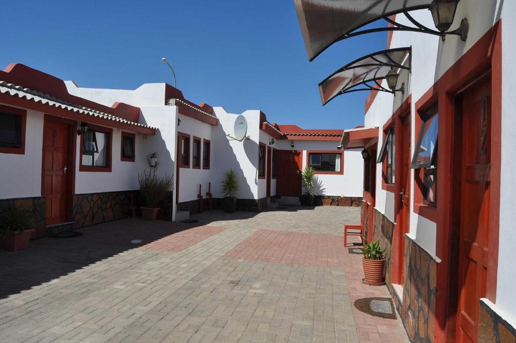 einen Innenhof eines Hauses mit weißen Häusern in der Unterkunft Timo's guesthouse accommodation in Lüderitz