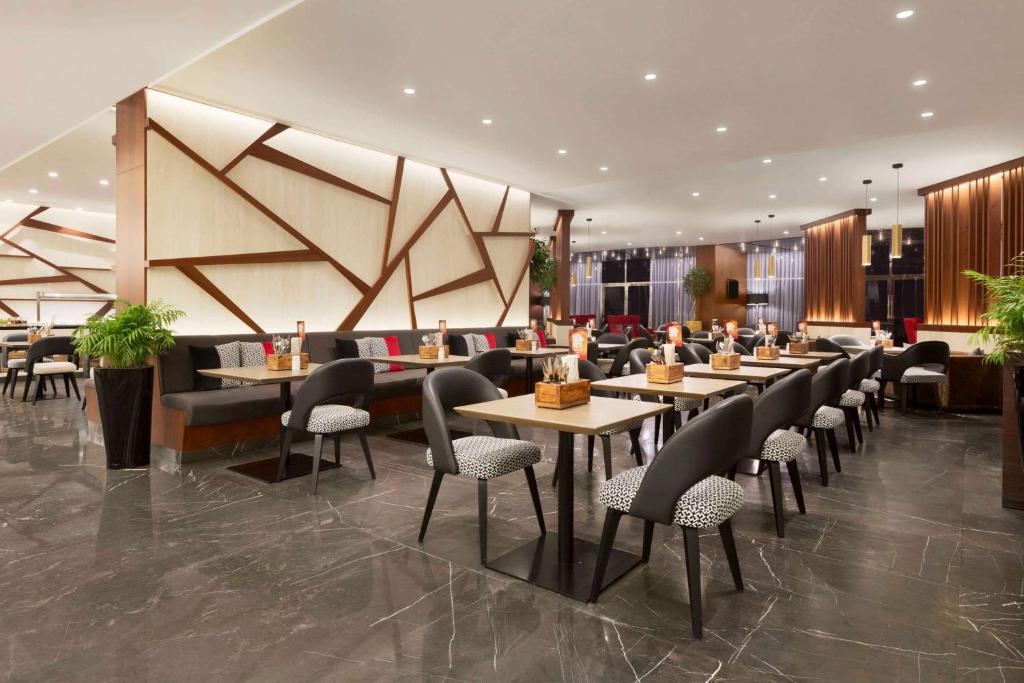 a restaurant with tables and chairs in a lobby at TRYP by Wyndham Dubai in Dubai