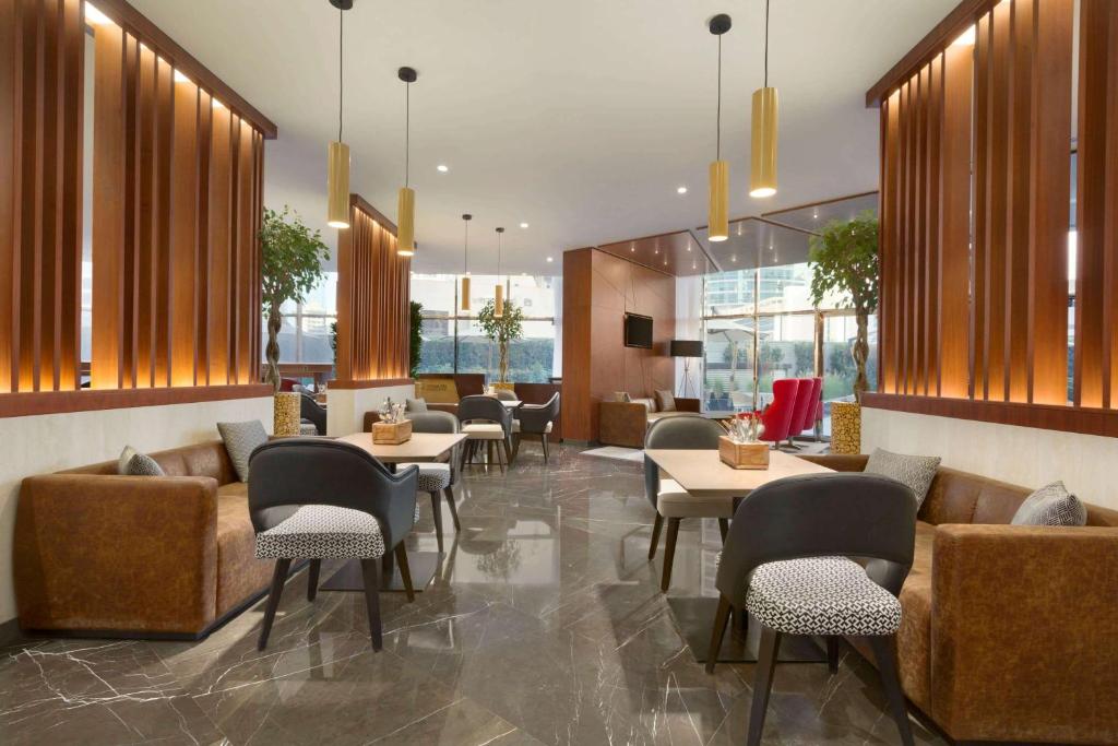 a restaurant with couches and tables and chairs at TRYP by Wyndham Dubai in Dubai