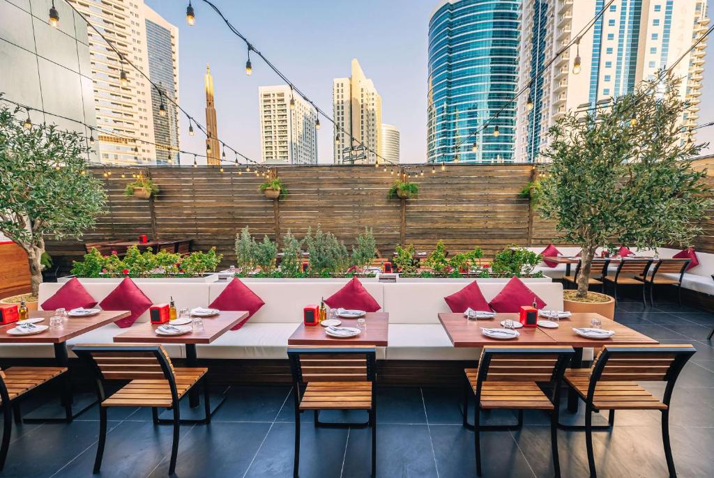 a restaurant with tables and chairs in a city at TRYP by Wyndham Dubai in Dubai
