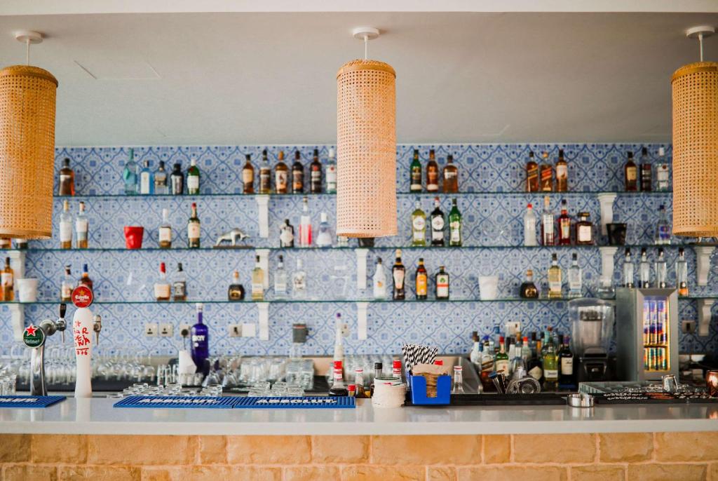 a bar with a blue tiled wall with bottles at TRYP by Wyndham Dubai in Dubai