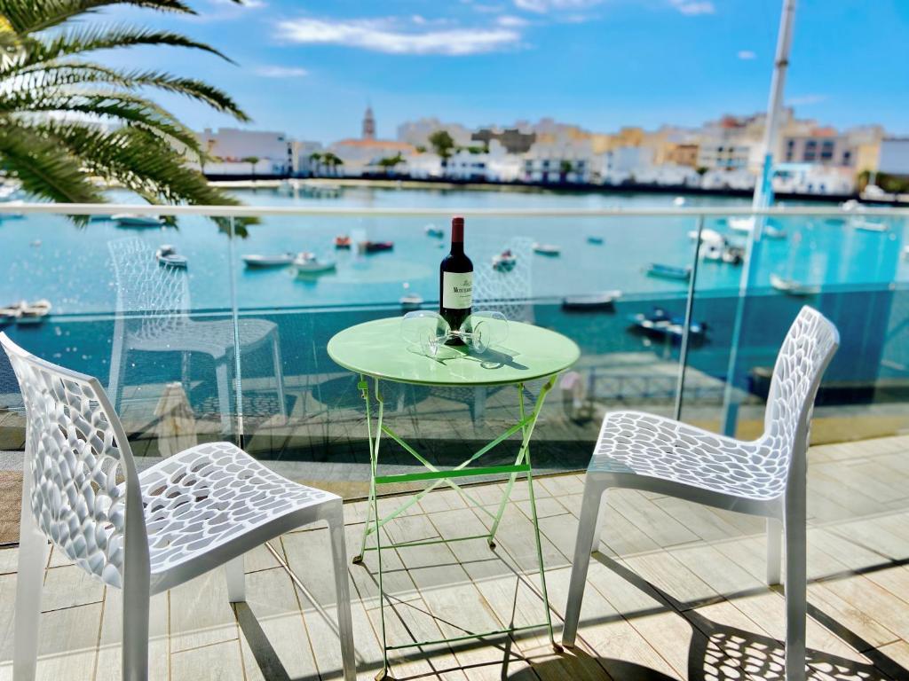 a table with a bottle of wine and two chairs at Charco Loft Panoramic Mirador ADULT ONLY in Arrecife
