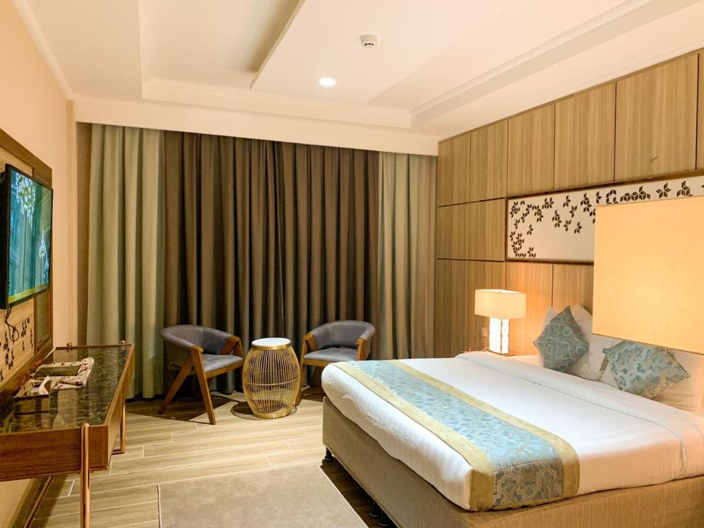 A bed or beds in a room at Midan Hotel & Suites Al Aziziya