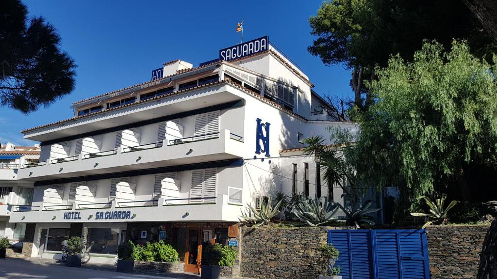 un edificio bianco con un cartello sopra di Hotel S´Aguarda a Cadaqués