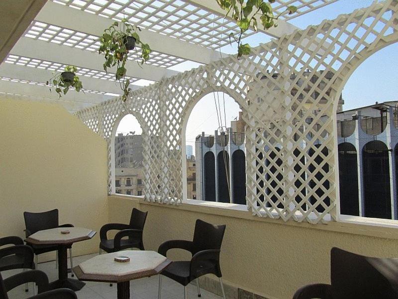 a restaurant with tables and chairs in a room with windows at Cairo Moon Hostel in Cairo