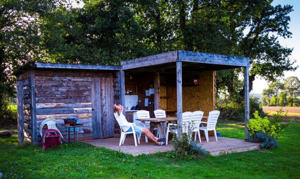 Noyal-Muzillacにあるcamping chez l'habitantの小屋のテーブルに座る女