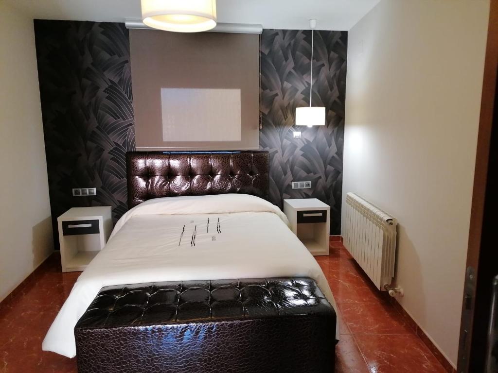 1 dormitorio con 1 cama grande y cabecero de cuero en Casa de la abuela digit@l, en Martín del Río