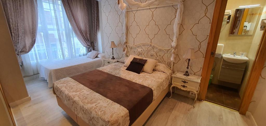 sypialnia z 2 łóżkami i umywalką w obiekcie Hosteria Villa de Castro w mieście Castro-Urdiales