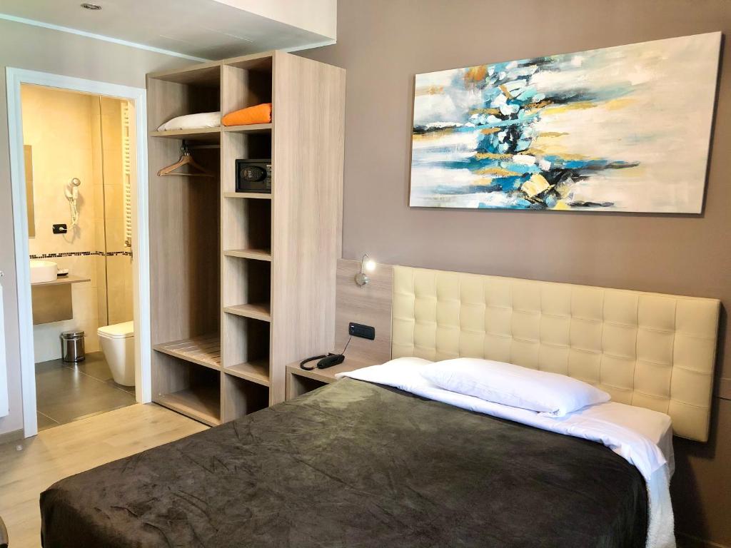 1 dormitorio con 1 cama y una pintura en la pared en Hotel Folen en Milán