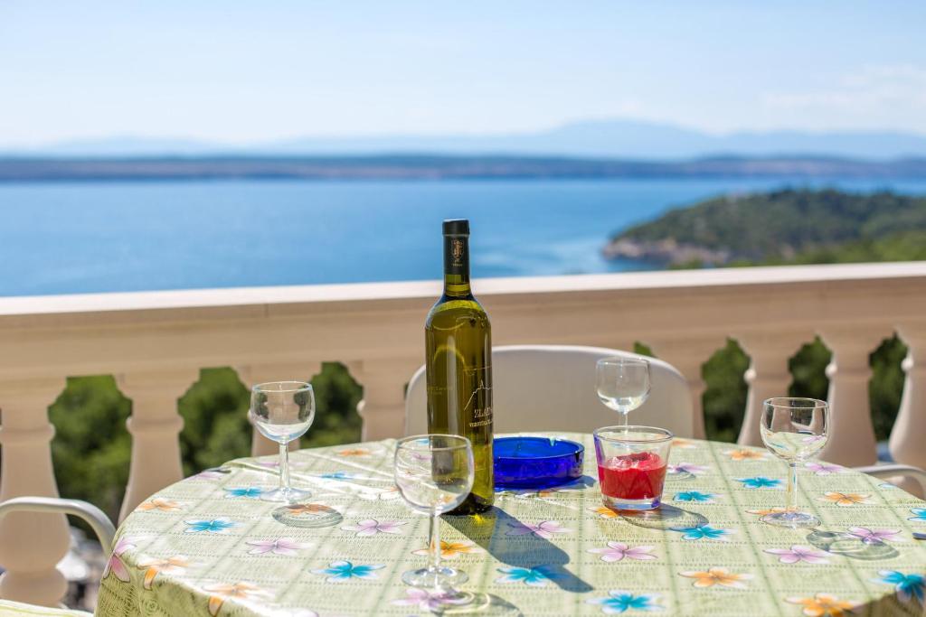 uma garrafa de vinho sentada numa mesa com copos de vinho em ANDELKO em Dramalj